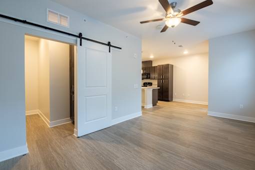 A room with a ceiling fan and a sliding door.