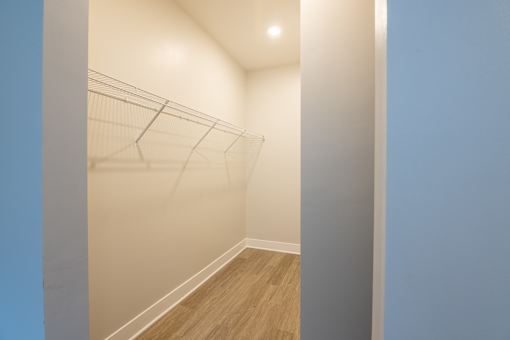 A hallway with a wooden floor and white walls.
