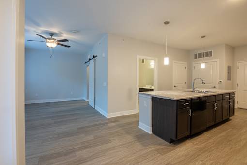 A kitchen with a fan on the ceiling and a countertop with cabinets.