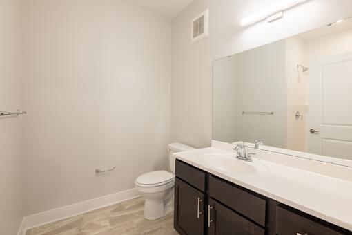 A white toilet sits next to a sink in a bathroom.