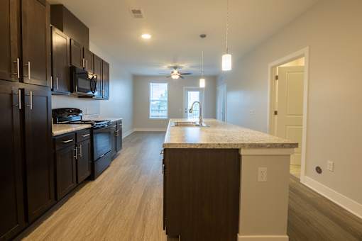 A kitchen with dark brown cabinets and a light brown island.