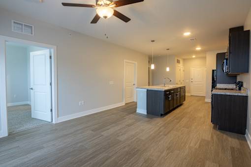 A spacious room with a ceiling fan and lighting fixtures.