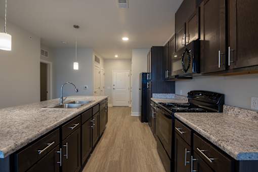 A kitchen with dark wood cabinets and granite countertops.