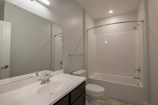 A white sink with a mirror above it and a toilet next to it.