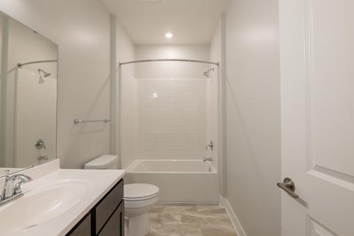 A white bathroom with a sink, toilet, and bathtub.