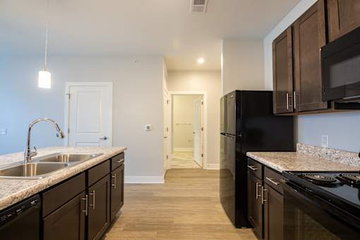 A kitchen with black appliances and wooden cabinets.