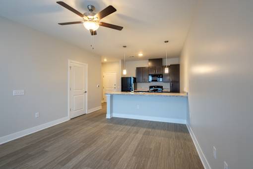 A room with a ceiling fan and a kitchen island.