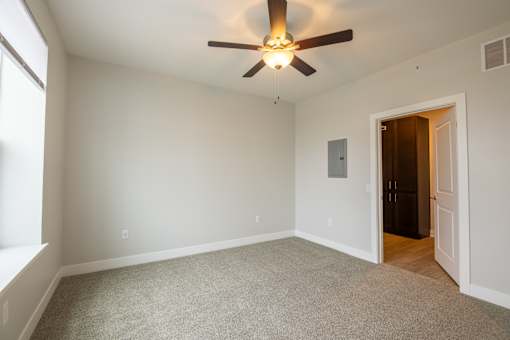 A room with a ceiling fan and a door.