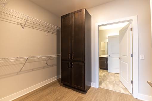 A large wooden wardrobe with a mirror above it.