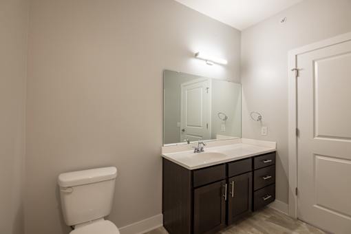 A white toilet sits next to a sink in a bathroom.
