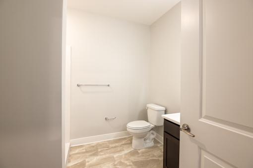 A white toilet sits in a bathroom next to a white door.