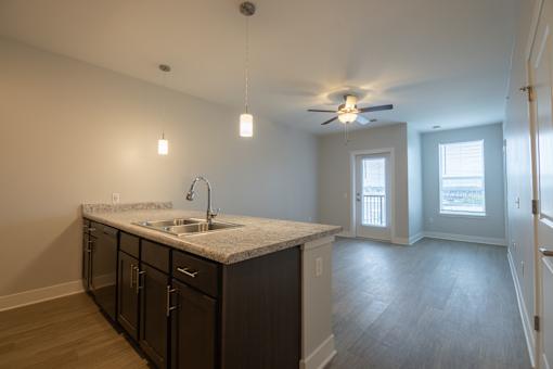 A kitchen with a marble countertop and a ceiling fan.