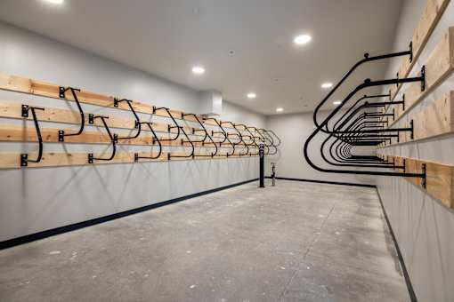 A long row of black pipes are attached to a wall.