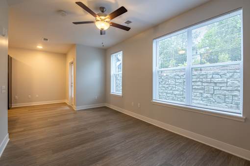 A room with a ceiling fan and a window with blinds.