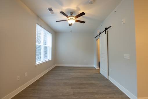 A room with a ceiling fan and a window.