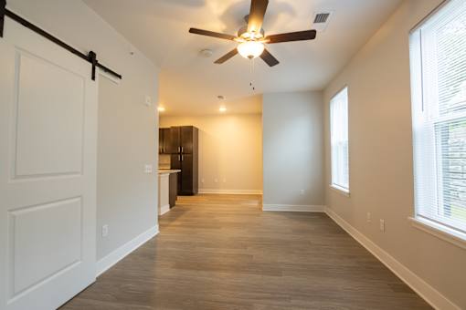 A room with a ceiling fan and a door.