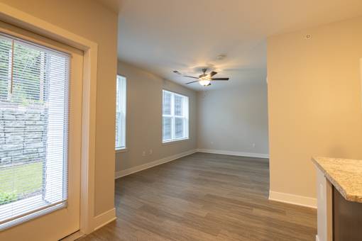 A room with a ceiling fan and a window with blinds.