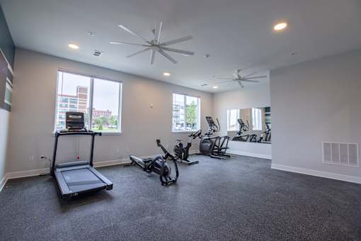 A spacious room with a treadmill, exercise bike, and other workout equipment.