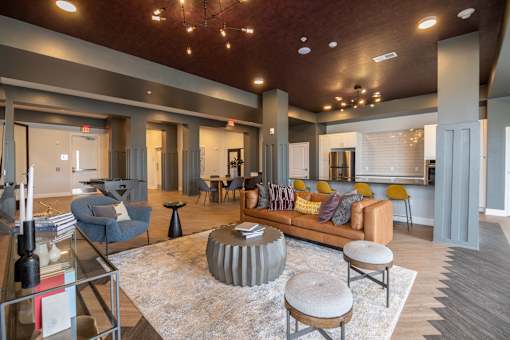 A living room with a grey rug and a round table in the middle.