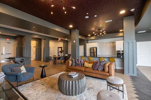 A living room with a brown couch and a grey armchair.