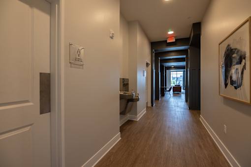 A hallway with a white door and a brown floor.