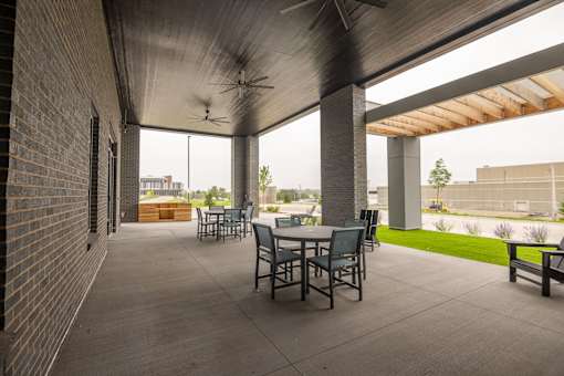 A patio with a table and chairs under a roof.