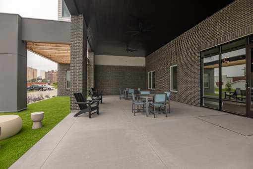 A patio with a table and chairs is surrounded by a brick wall.