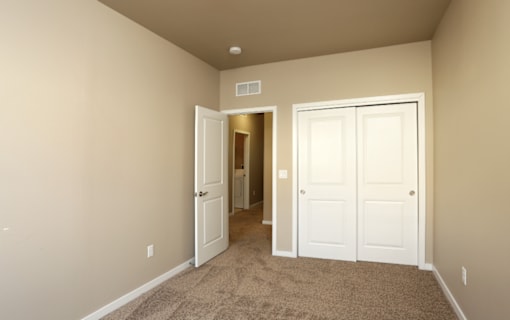 Comfortable Bedroom With Accessible Closet at 7th Street Brownstones, Indigo Living, IA, Iowa