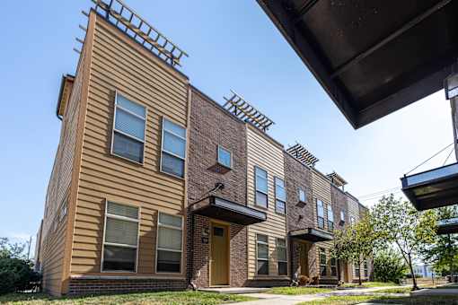 Building with a sidewalk in front of it at 7th Street Brownstones, Indigo Living, Iowa