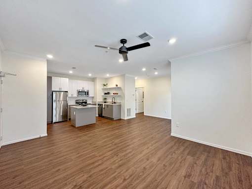 an empty living room with a kitchen and a ceiling fan at 92West, Iowa  