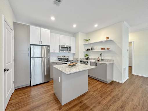 a large kitchen with stainless steel appliances and white cabinets at 92West, West Des Moines, 50266  