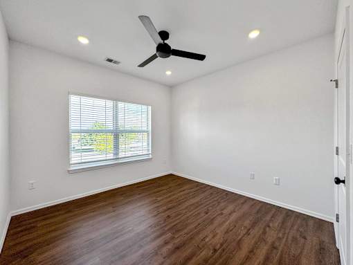 an empty living room with a ceiling fan and a window at 92West, Iowa, 50266