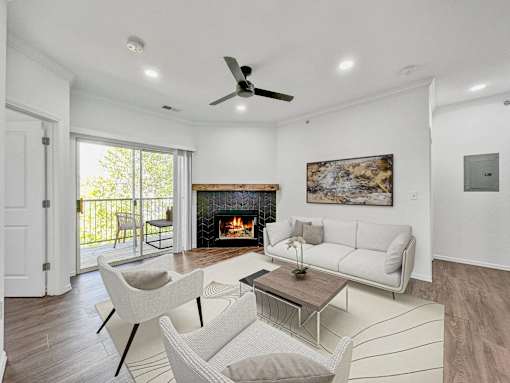 a living room with couches and chairs and a fireplace at 92West, West Des Moines  