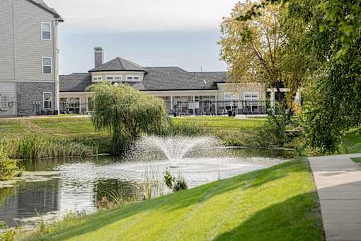 a pond with a fountain in front of a building at 92West, West Des Moines  
