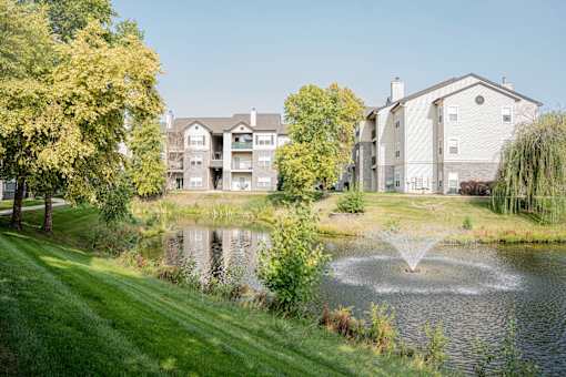a fountain in the pond with an apartment building in the background at 92West, West Des Moines, IA 50266  