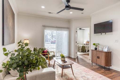 A living room with a couch, chair, and a potted plant.