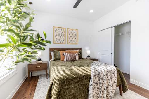 A bedroom with a bed, nightstand, and two wall hangings.