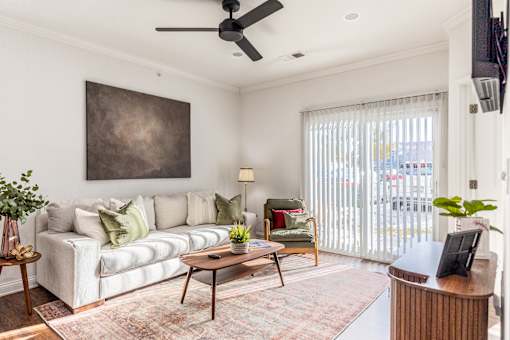 A living room with a white couch, a brown coffee table, and a painting on the wall.