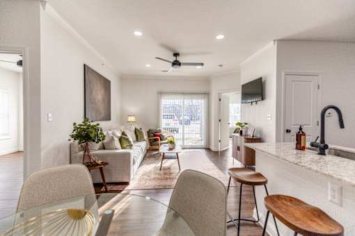 A modern living room with a glass table and chairs.