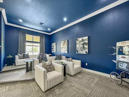 a living room with blue walls and white couches and chairs at 92West, West Des Moines, 50266  