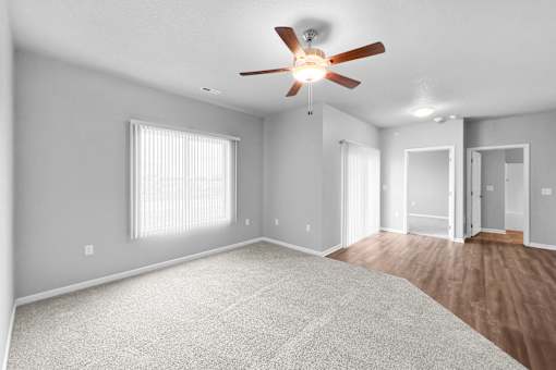 A spacious room with a ceiling fan and carpeted floor.