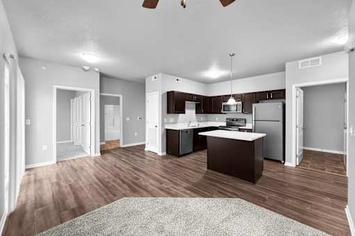 A kitchen with a refrigerator, sink, and stove is shown in this image.