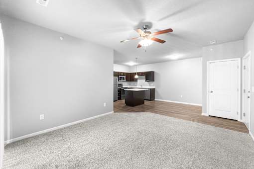 A spacious room with a ceiling fan and a carpeted floor.