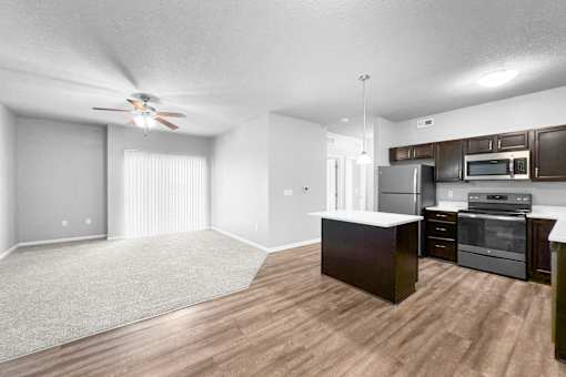 A spacious kitchen with dark wood cabinets and stainless steel appliances.