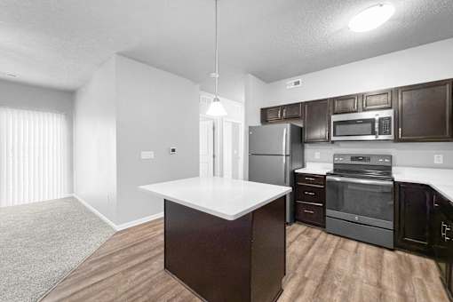 A kitchen with dark brown cabinets and stainless steel appliances.