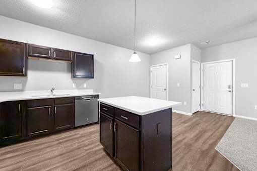 A kitchen with dark wood cabinets and a white countertop.