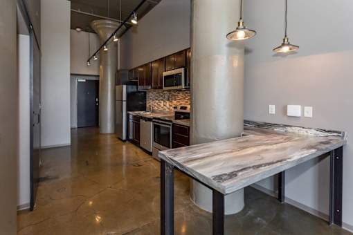 Kitchen with a marble counter top and a stainless steel at Ballyard Lofts, Indigo Living, IA, 50309