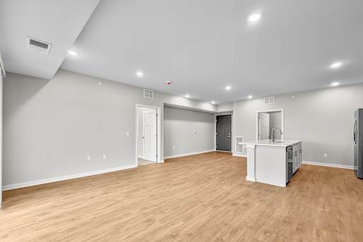 A large empty room with wooden floors and white walls.