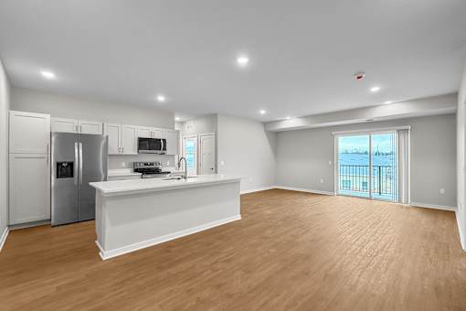 A spacious kitchen with a refrigerator, microwave, and oven.