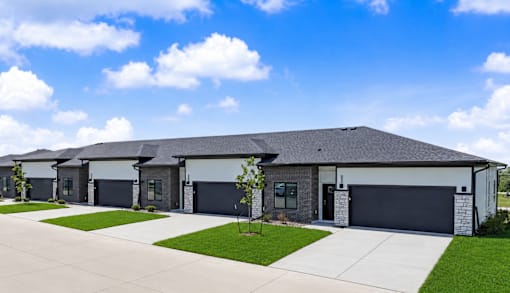 A row of houses with garages and driveways.